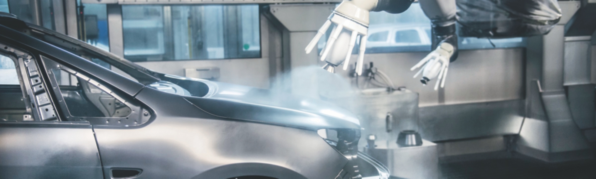 Robotic arm applying coating to automobile frame Robotic arm applying coating to automobile frame